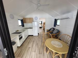 een keuken en een eethoek van een caravan met een tafel en stoelen bij Ellis Beach Oceanfront Holiday Park in Palm Cove