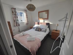 a bedroom with a bed with two towels on it at Shoreline Seaside Holiday Home Aberavon beach in Port Talbot