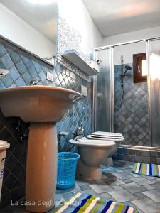 a bathroom with a sink and a toilet at La Casa Degli Specchi-villetta con due giardini in La Maddalena
