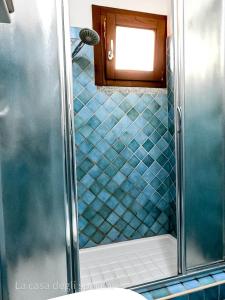 a bathroom with a shower with blue tiles at La Casa Degli Specchi-villetta con due giardini in La Maddalena
