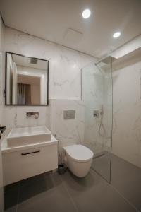 une salle de bains avec toilettes, lavabo et miroir dans l'établissement SeA apartments, à Saranda