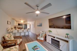 a living room with a ceiling fan and a fireplace at Kauai Vacation Rental Walk to Kalapaki Beach! in Lihue