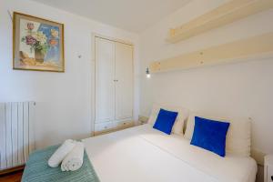 a bedroom with a white bed with blue pillows at Casa Nelly in Ospedaletti