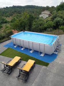 a large swimming pool with two chairs and a table at Casa Marmelos - Alojamento Local in Ourém