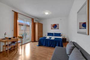 a bedroom with a blue bed and a table at Residence Apartments in Makarska