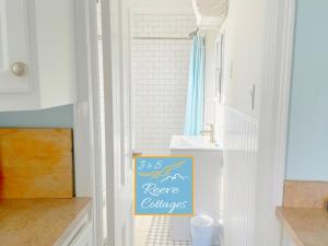 une cuisine avec un panneau sur la porte d'une pièce dans l'établissement Premier Waterfront Cottage 2, à Riverhead 45 autres photos