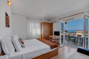 a bedroom with a bed and a view of the ocean at Residence Apartments in Makarska