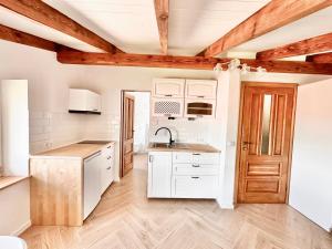 a kitchen with white cabinets and a wooden ceiling at Gackowo in Ostróda