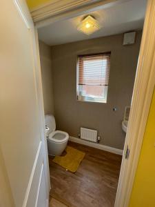 an empty bathroom with a toilet and a window at Holiday Home In Cardiff, Sleeps 8 in Cardiff +49 photos