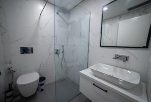 une salle de bains blanche avec toilettes et lavabo dans l'établissement SeA apartments, à Saranda 16 autres photos