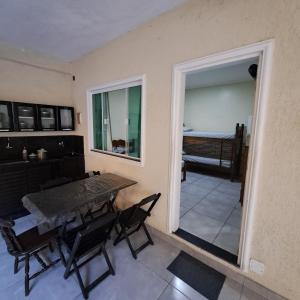 Un comedor con mesa y sillas y una ventana. en Suíte Caminho do Sol, en Arraial do Cabo