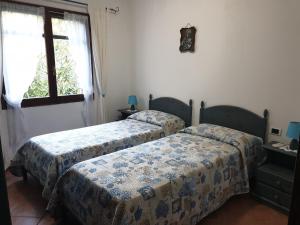 維拉普特祖的住宿－Villetta Porto Corallo，一间卧室设有两张床和窗户。