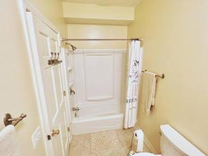 a white bathroom with a shower and a toilet at Serenity View Lakeside Retreat on Lake Murray, SC in Lake Murray Shores +59 photos