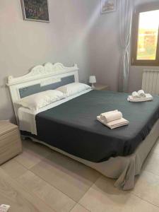 a bedroom with a large bed with two towels on it at Rome's Harbour all year in Lido di Ostia