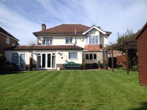 a house with a large lawn in front of it at LA B&B in Chichester