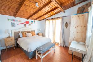 a bedroom with a bed and a wooden ceiling at Cabaña En la Playa in Maitencillo