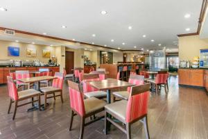un restaurante con mesas y sillas y una cocina en Comfort Suites Forrest City, en Forrest City