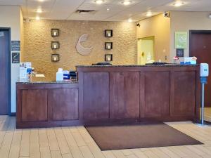 a lobby with a large wooden counter in a store at Comfort Suites Farmington in Farmington