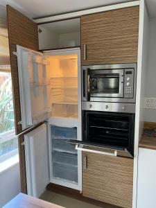 eine Küche mit einem offenen Kühlschrank und einer Mikrowelle in der Unterkunft Holiday Home In Cardiff, Sleeps 8 in Cardiff