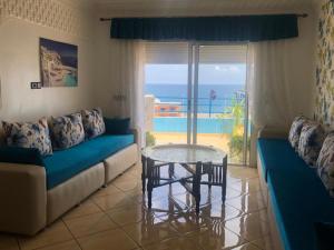 sala de estar con sofá y mesa de cristal en Grand appart avec vue sur mer, en Oued Laou