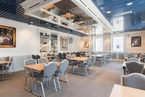 une salle à manger avec des tables et des chaises en bois dans l'établissement Scandic City, à Fredrikstad