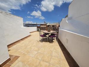 d'une terrasse avec une table et des chaises sur un balcon. dans l'établissement Casa el albaicin, à Alhaurín el Grande