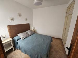 - une petite chambre avec un lit et une couverture bleue dans l'établissement Casa el albaicin, à Alhaurín el Grande