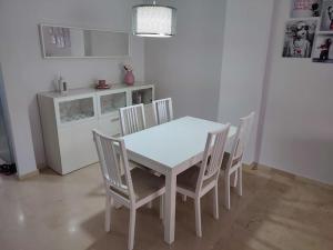 un tavolo bianco e sedie in cucina di Sunny Guadalmina Apartment a Marbella