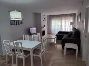 sala de estar con mesa, sillas y sofá en Sunny Guadalmina Apartment, en Marbella