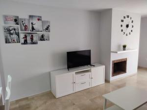 soggiorno con TV su un armadietto bianco di Sunny Guadalmina Apartment a Marbella