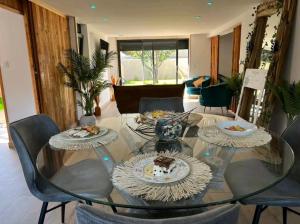a glass table with plates of food on top of it at ESCAPE ZEN Oasis tropicale & Spa privatif in Loon-Plage