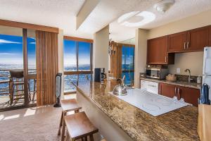 a kitchen with a counter and some chairs and windows at Kuhio Shores 416 in Koloa