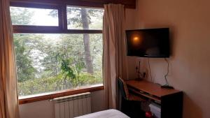 - une chambre avec un bureau, une télévision et une fenêtre dans l'établissement Kaulemu, à San Carlos de Bariloche