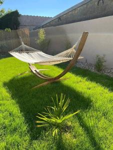 a hammock sitting in the grass next to a plant at ESCAPE ZEN Oasis tropicale & Spa privatif in Loon-Plage