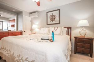 een slaapkamer met een groot wit bed en een fles tandpasta bij Kuhio Shores 208 in Koloa