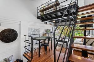 a spiral staircase in a room with a table and chairs at Fabrik Loft Central New York Stylequiet in Fremantle