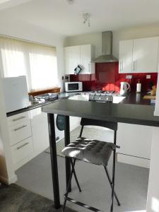a kitchen with a table and a chair in it at Charming 2 bed house Perfect base for sightseeing in Johnstone