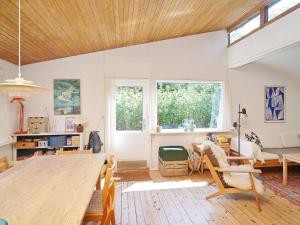 una sala de estar con una gran mesa de madera y sillas en Holiday home Frederiksværk XXIV, en Frederiksværk