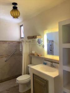 a bathroom with a toilet and a sink and a mirror at Cabo Vista Hotel Adults Only in Cabo San Lucas