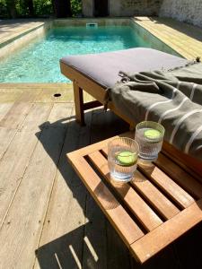 a pool with a bed and two candles on a wooden table at Maison Balmelle - Maison d'hôtes de Caractère in Gramat