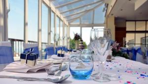 a table with a white table cloth with wine glasses at The Riviera Hotel & Apartments - Alum Chine in Bournemouth