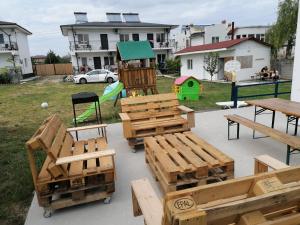 un parque infantil con bancos de madera y un columpio en La Tortuga - Vama Veche en Vama Veche