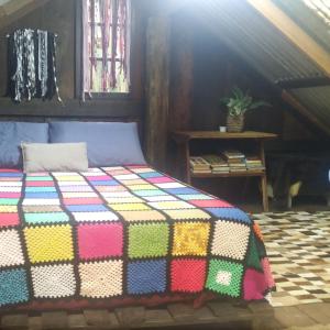 a colorful quilt on a bed in a room at Cabana Bambu in Sapiranga