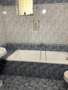 a bathroom with a white tub and a toilet at Christina's house with 2 bedrooms and free parking in Gjirokastër