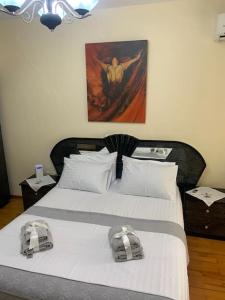 a bedroom with a large bed with white sheets at Christina's house with 2 bedrooms and free parking in Gjirokastër