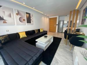 uma sala de estar com um sofá preto e uma mesa em Corniche Casablanca - Black New em Casablanca