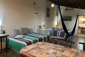 a room with two beds and a hammock in it at Bungalow La Media Luna Brisas de Zicatela in Brisas de Zicatela