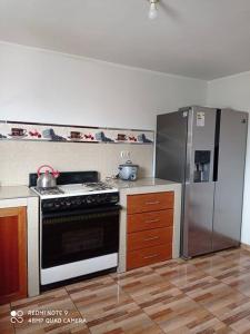 a kitchen with a stove and a refrigerator at casa hospedaje regina marie in Huaraz