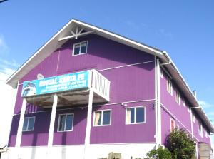 ein großes lila Gebäude mit einem Schild darauf in der Unterkunft Hostal Santa Fe in Castro