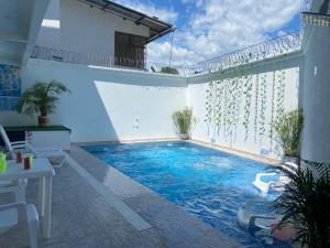 a swimming pool in the middle of a room with a white wall at Casa Hawai in Melgar